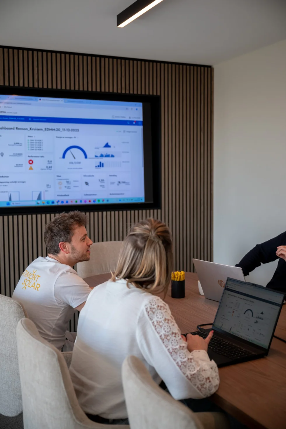 Energiedashboard met verbruiks- en vermogensgrafieken op het scherm in de vergaderzaal