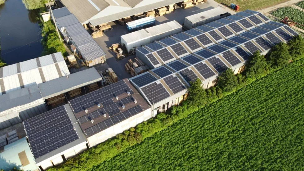 Luchtfoto van de loodsen van Houthandel Devreese met zonnepanelen
