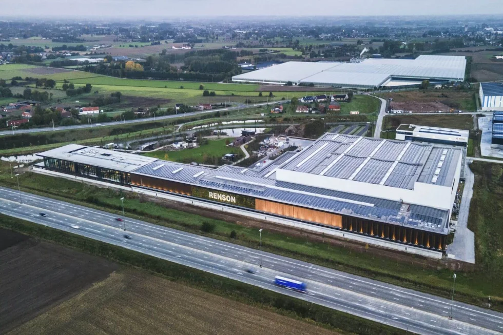 Luchtfoto van de langgerekte productiesite van Renson met zonnepanelen op het dak