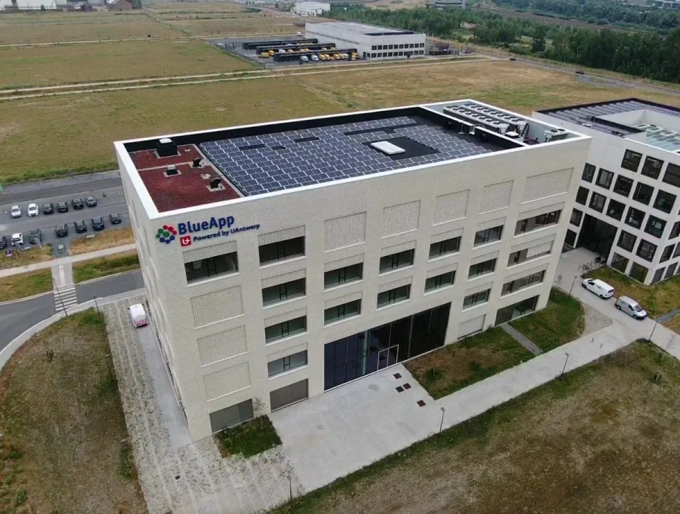 Luchtfoto van het BlueApp-gebouw van de Universiteit Antwerpen met zonnepanelen