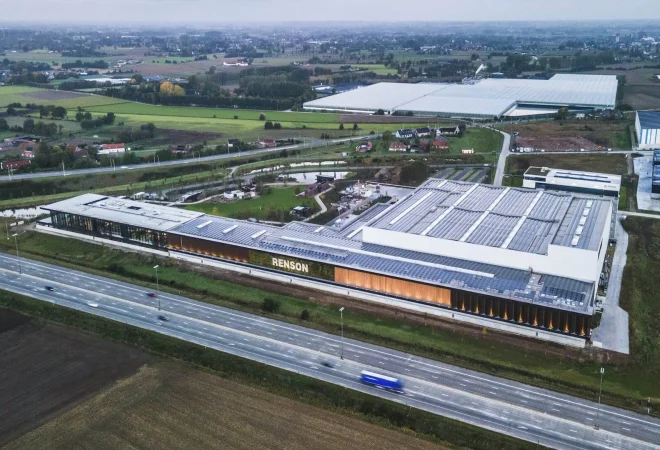 Luchtfoto van de langgerekte productiesite van Renson met zonnepanelen op het dak