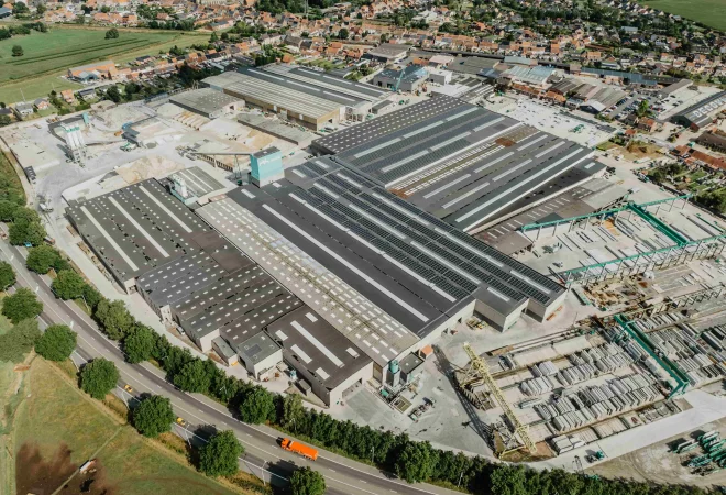 Luchtfoto van de volledige bedrijfssite van Valcke Industriebouw met zonnepanelen op alle daken