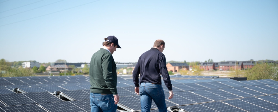 Twee medewerkers inspecteren de installatie op het dak