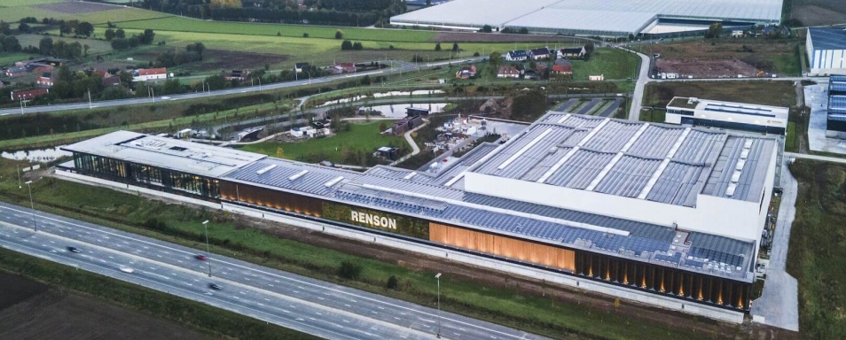 Luchtfoto van de langgerekte productiesite van Renson met zonnepanelen op het dak