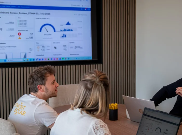 Energiedashboard met verbruiks- en vermogensgrafieken op het scherm in de vergaderzaal