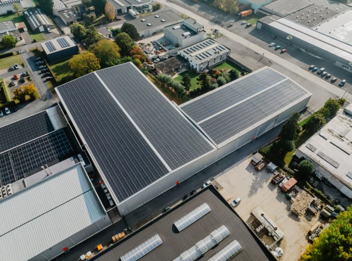 Luchtfoto van een langgerekt productiedak volledig belegd met zonnepanelen