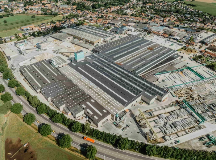 Luchtfoto van de volledige bedrijfssite van Valcke Industriebouw met zonnepanelen op alle daken