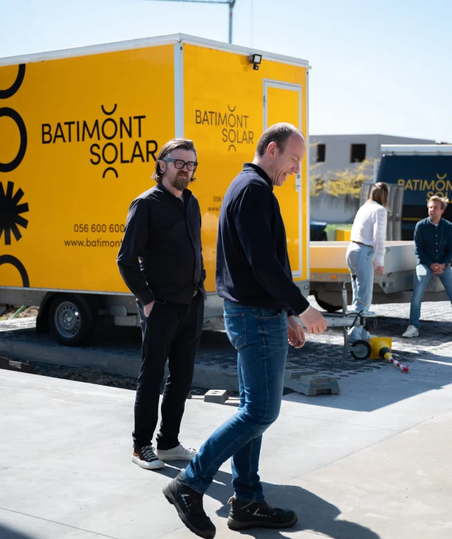 Medewerkers op de parking voor een vrachtwagen van Batimont Solar