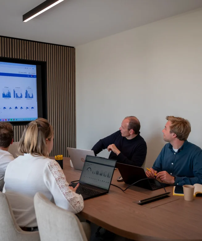 Team in de vergaderzaal met een energiedashboard op het scherm