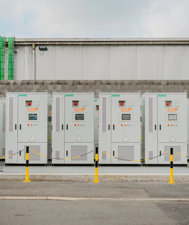 Rij batterijkasten in buitenopstelling langs een bedrijfsgebouw