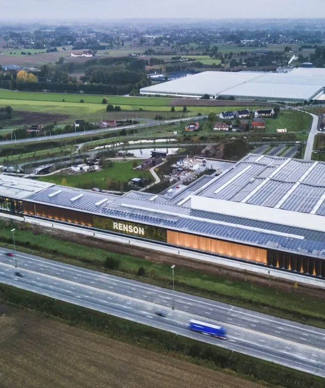 Luchtfoto van de langgerekte productiesite van Renson met zonnepanelen op het dak