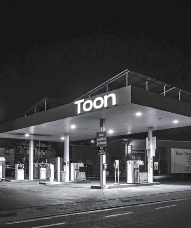Tankstation bij nacht met zonnepanelen op de luifel